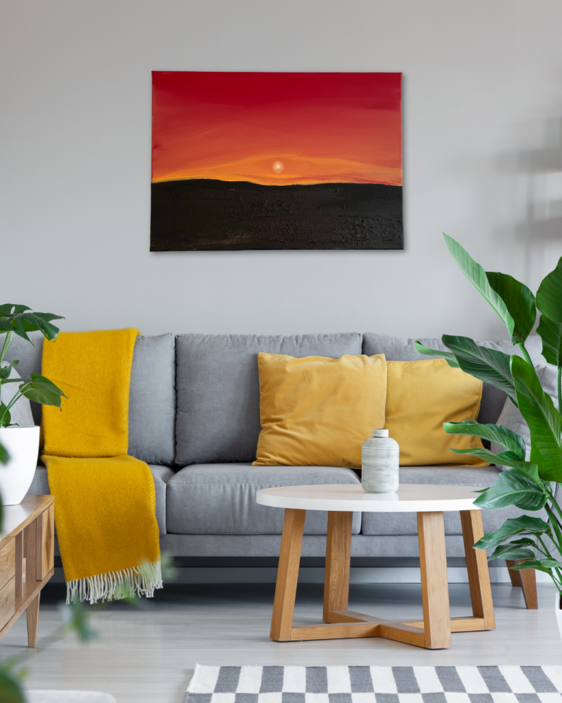 Sternzeichen und Kunst: Dieses Gemälde passt sehr gut zum Sternzeichen Krebs. Es stellt einen abstrakten Sonnenuntergang dar. Das Gemälde hängt im Wohnzimmer über einer grauen Couch mit gelben Kissen und einer gemütlichen gelben Decke.