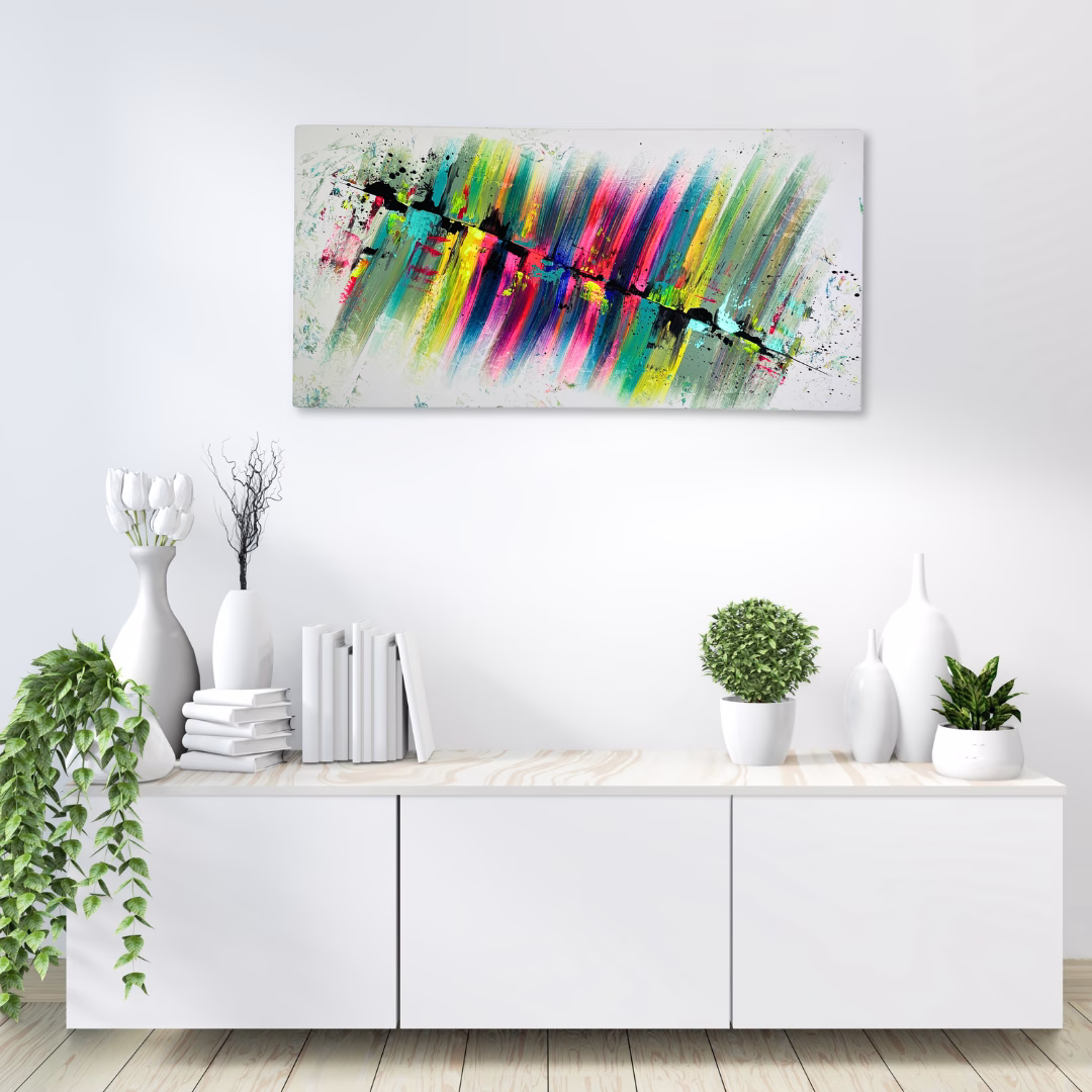 Buntes Acrylgemälde auf Leinwand an einer weißen Wand über einem weißen Sideboard. Das Leinwandbild wurde von der deutschen Künstlerin Janiscolorart von Hand gemalt und ist ein Unikat. Die Maße des schönen Bildes sind 50 cm x 100 cm.
