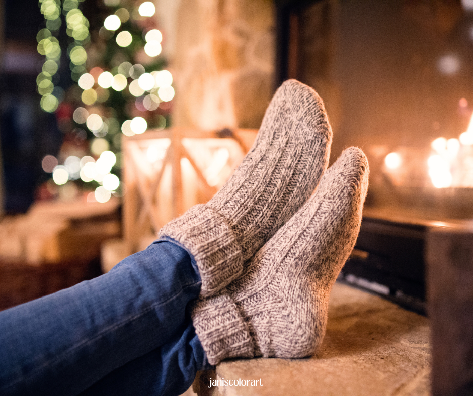 Füße in beige Wollsocken am Kamin hochlegen sorgt für Skandi Weihnachtsstimmung und ein behagliches Gefühl.