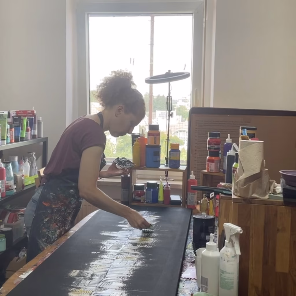 Die deutsche Künstlerin Janiscolorart beim Malen mit Acrylfarben und Malmesser in ihrem Atelier in Neunkirchen.